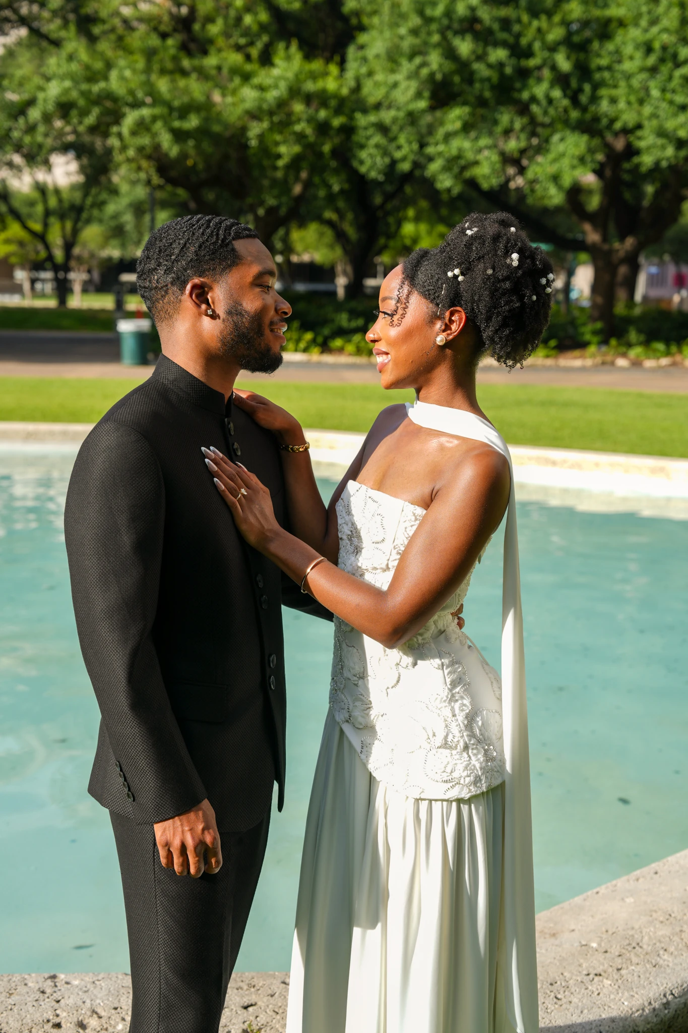 Engaged Houston couple embracing beside an indoor fountain