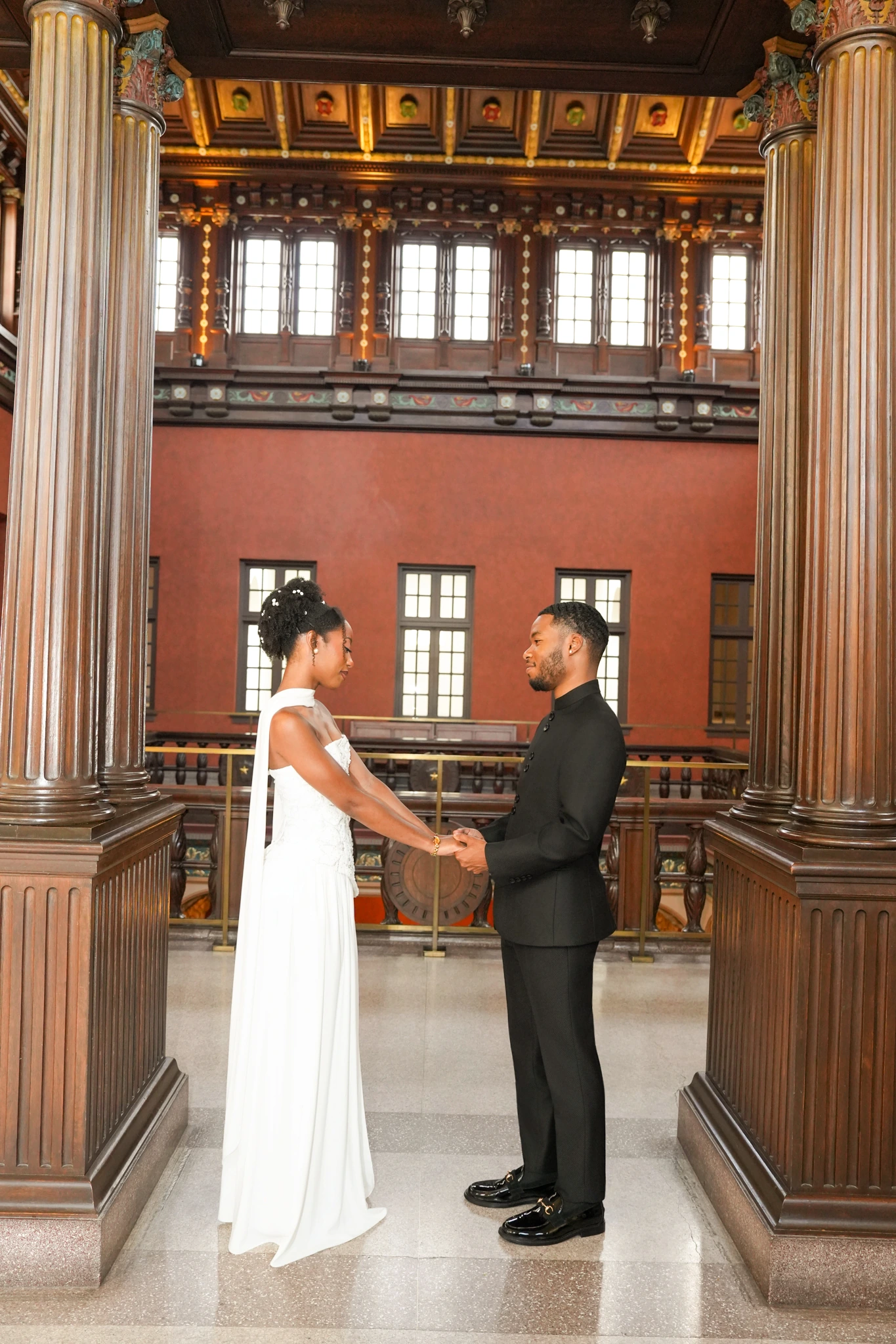 Houston engagement couple holding hands beneath historic columns