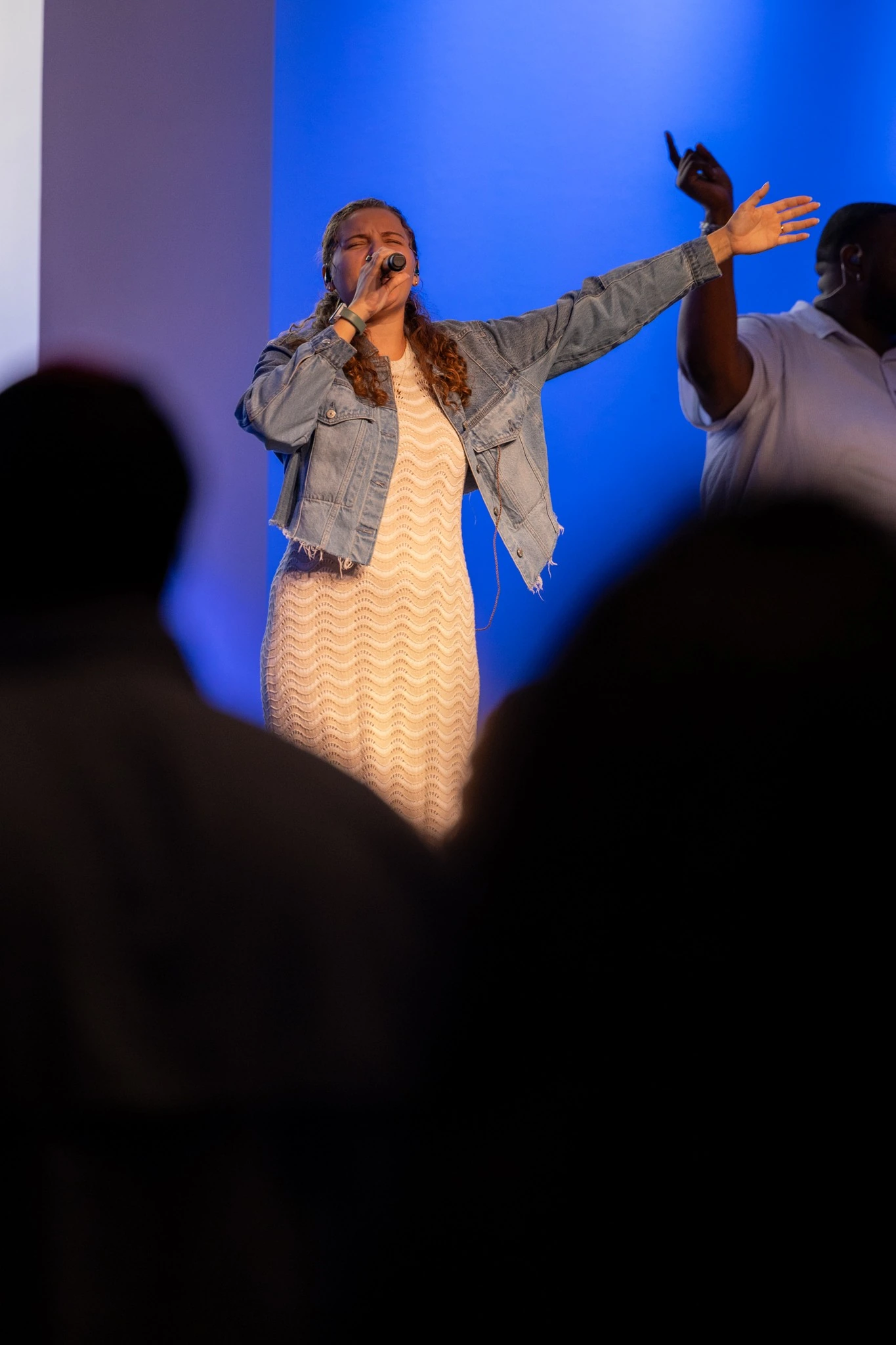 Vocalist raising her hand during an expressive live performance
