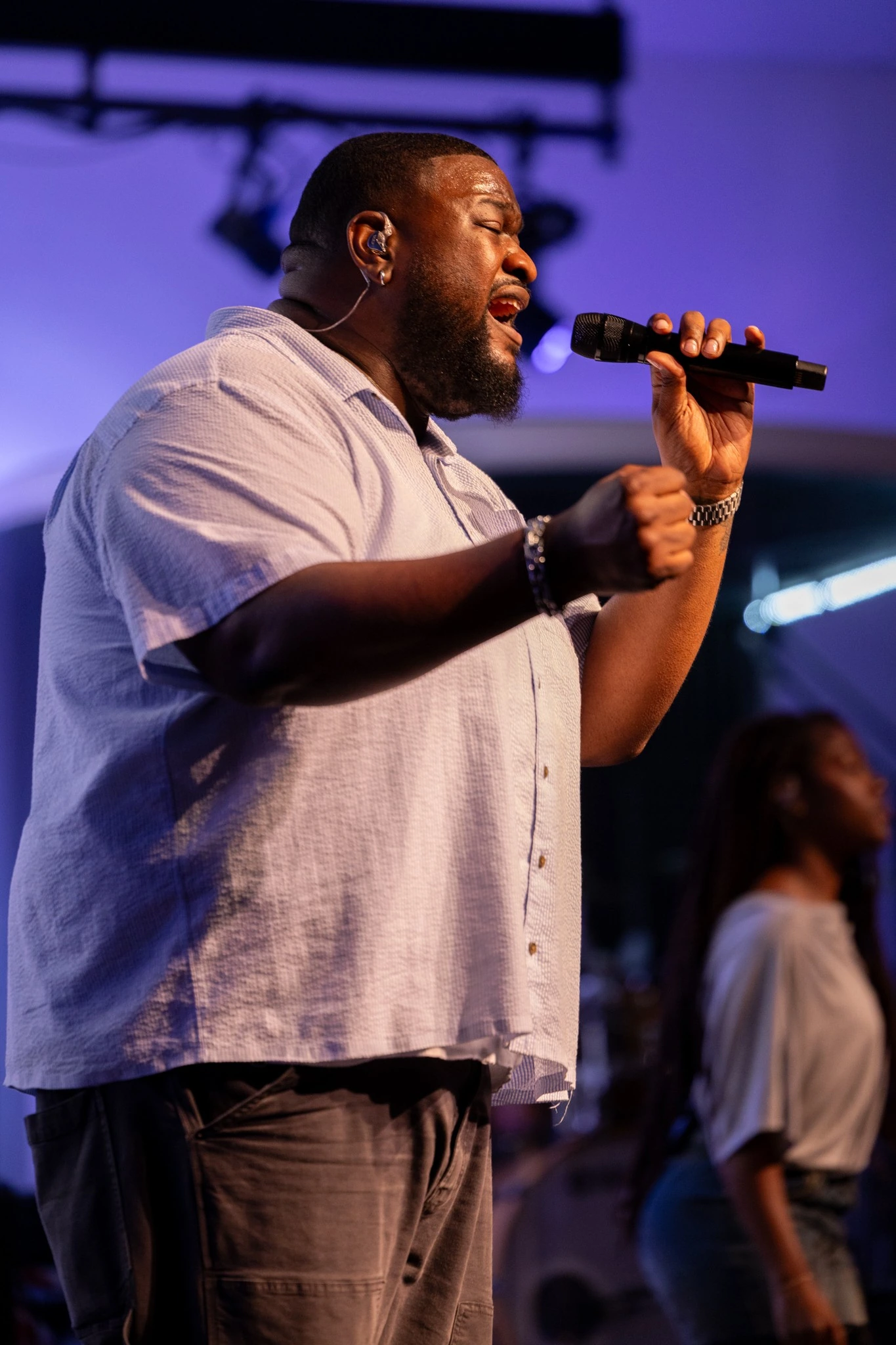 Male vocalist singing into a microphone during a Houston live event