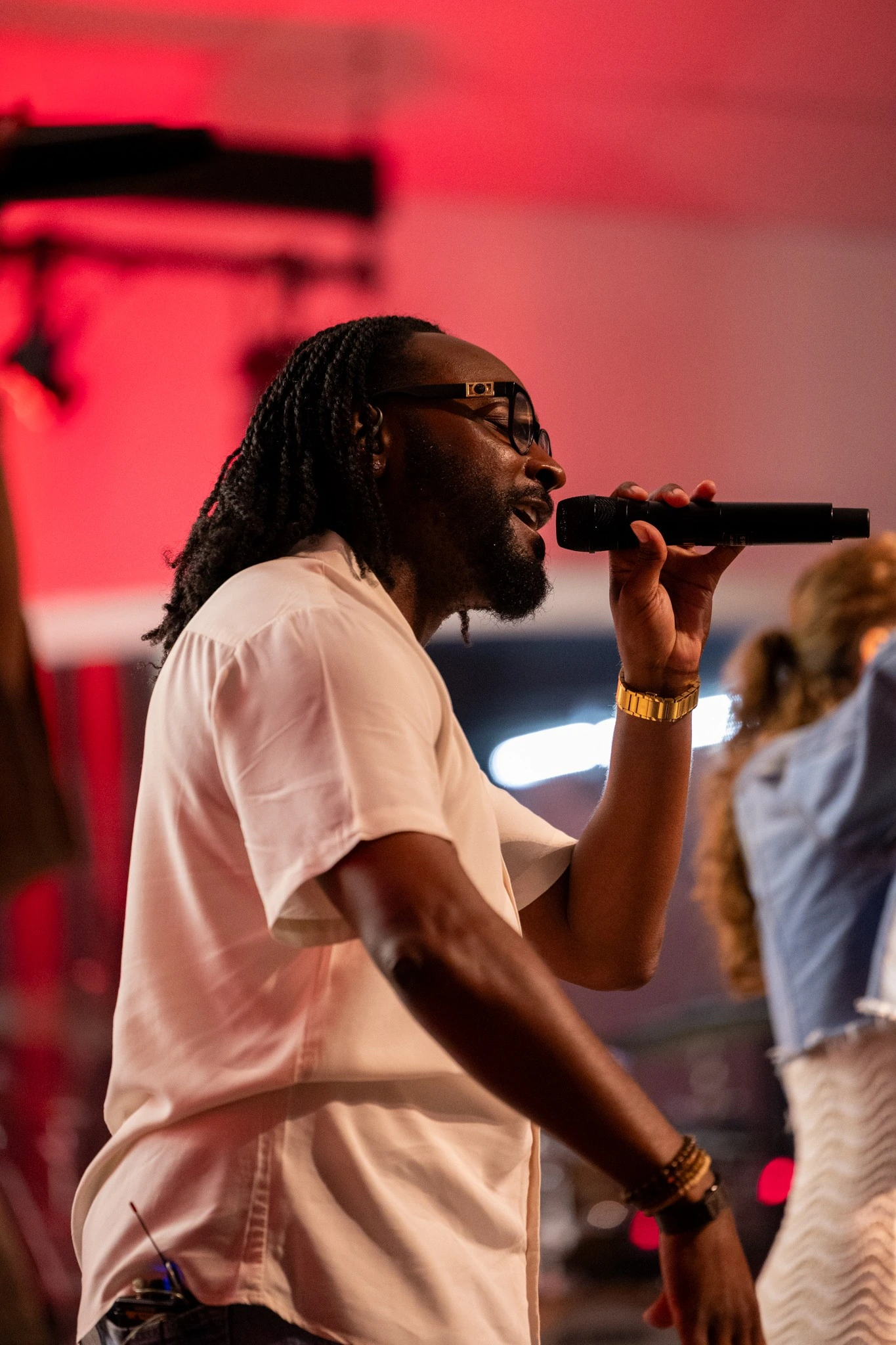 Male vocalist performing beneath red stage lighting